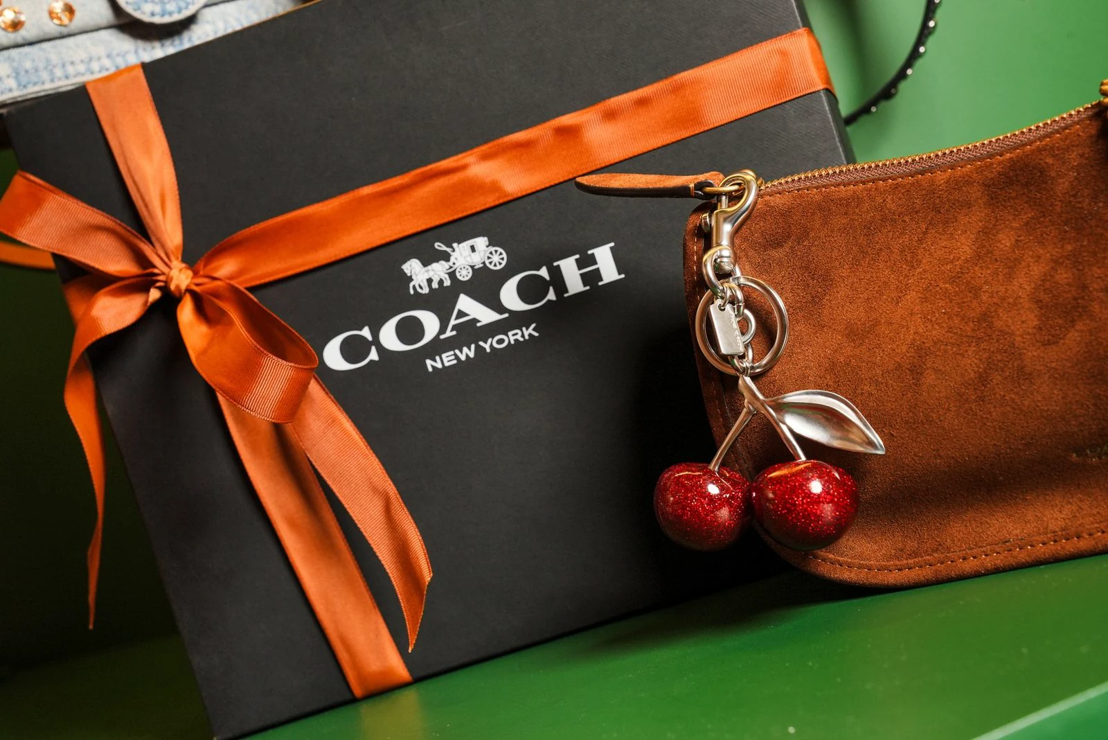 Digital content for Coach produced by ZerezoFilms: suede bag with a cherry charm and a gift box with an orange bow