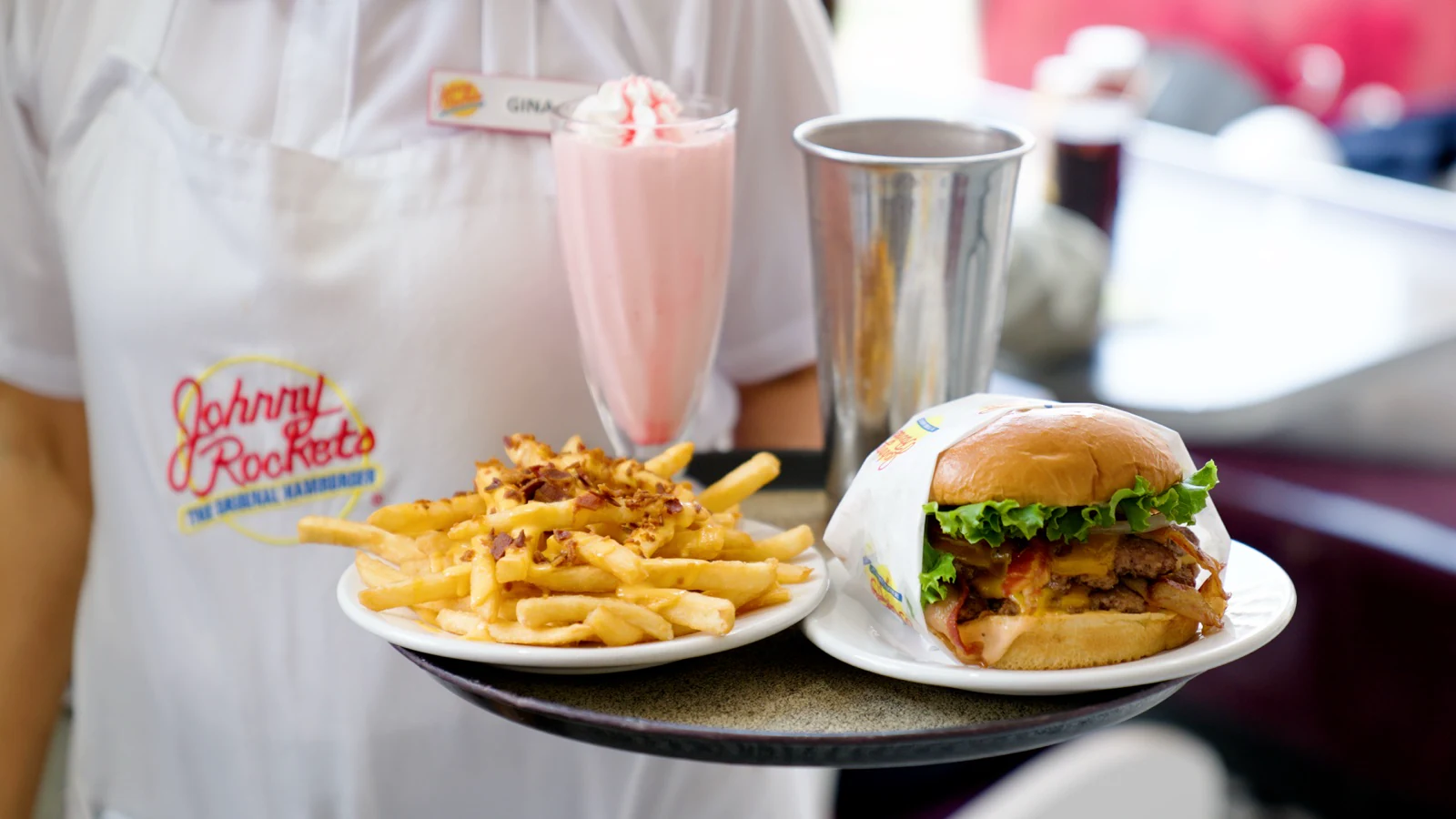 Fotografía gastronómica publicitaria para Johnny Rockets por ZerezoFilms: mesera con charola de hamburguesas y malteada