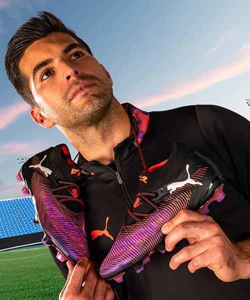 Puma FUTURE campaign produced by ZerezoFilms: player with black and purple boots over his shoulders in a stadium at dusk