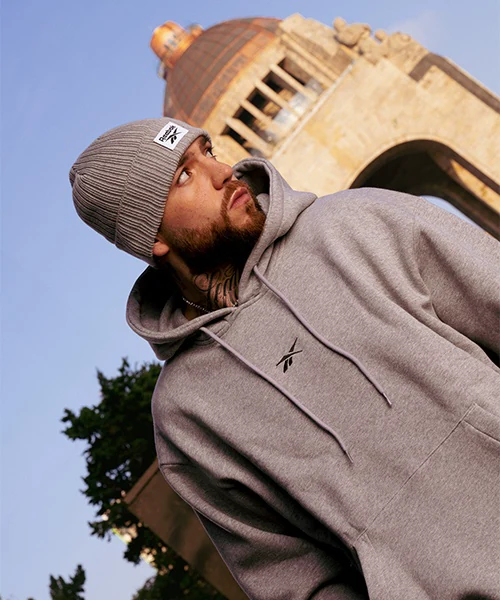 Reebok campaign photography in Mexico City by ZerezoFilms: man in a beanie and gray hoodie in front of the Monument to the Revolution
